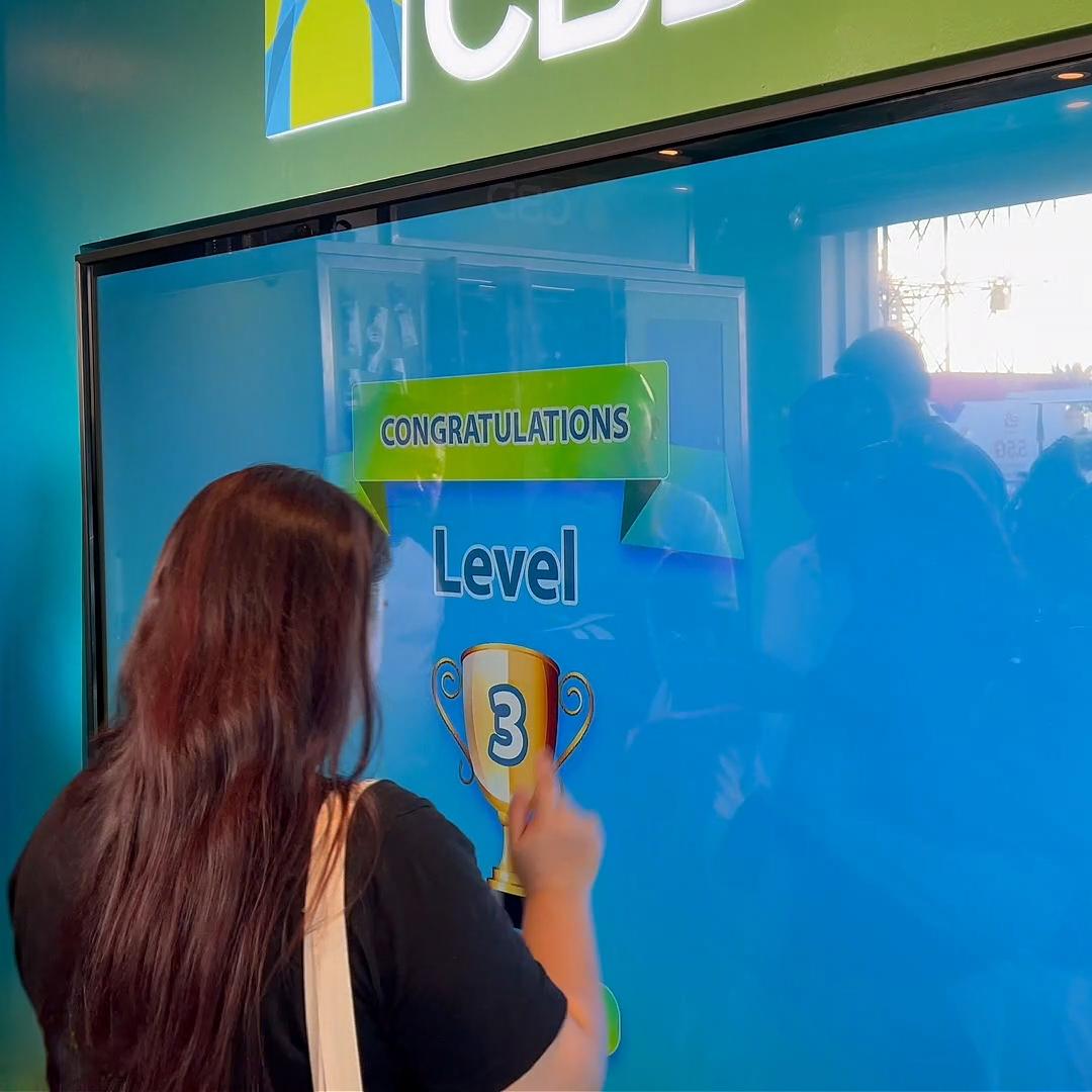 People playing a multi-level interactive financial literacy game at a brand activation event in Dubai, learning how to save and invest money.